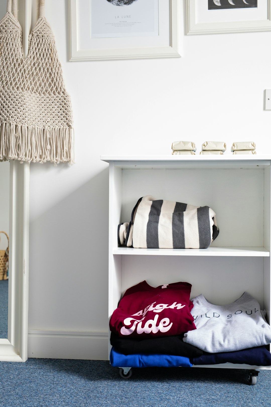 folded-clothes-and-striped-bag-on-shelf-pfmbnax2dgm